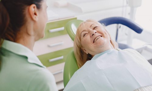 Senior woman having dental treatment at dentist's office. Woman is being treated for teeth